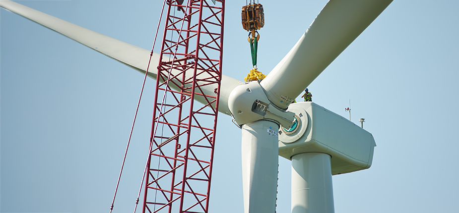 A wind turbine being built with a crane